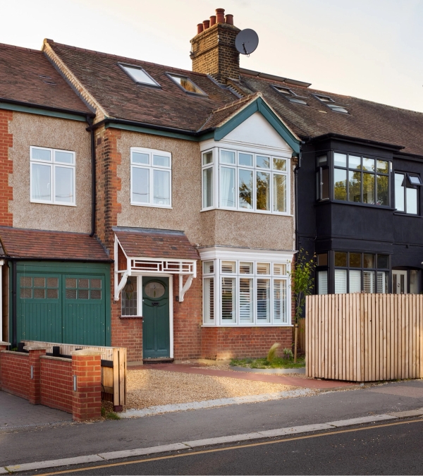 Front facade view of a remodelled double-fronted 1930s semi-detached house with timber slatted fence and driveway in Walthamstow, Love Locations E17.