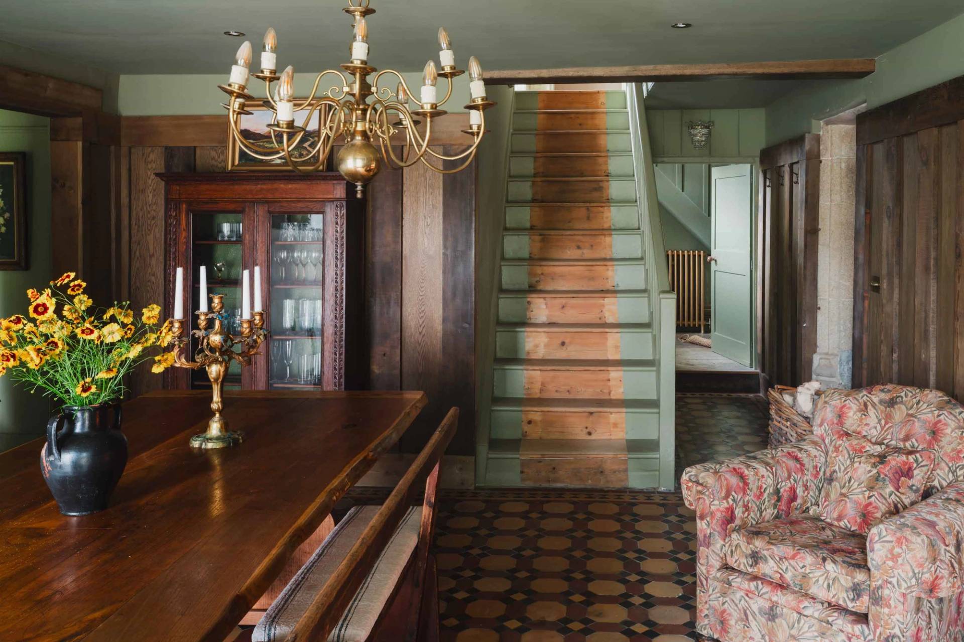 Dark wood panelled dining room and staircase transition in a Grade II-listed Cornish manor house via Love Locations.
