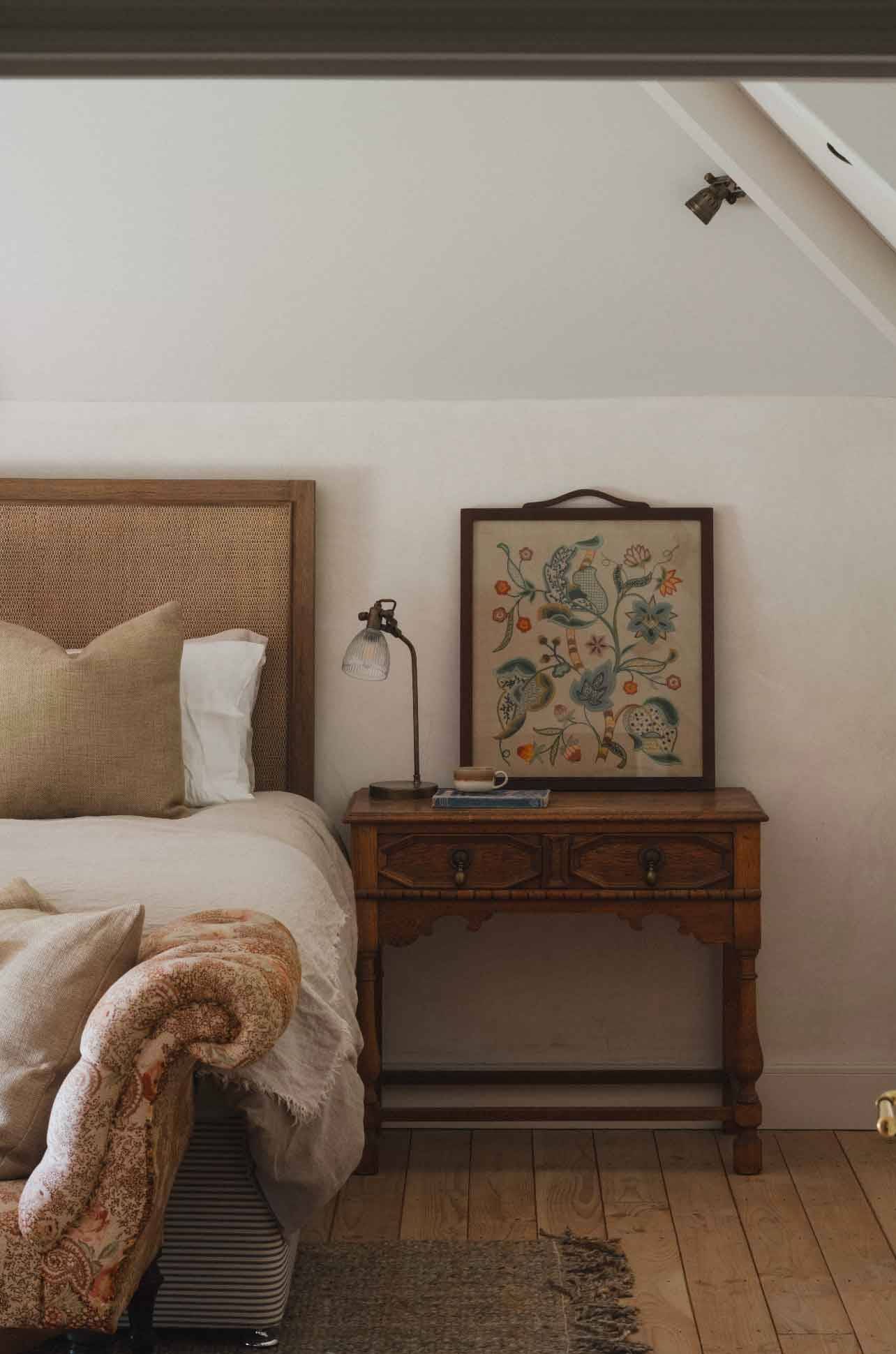 Cozy master bedroom detail showing a cane headboard and vintage wooden side table in Newquay Cornwall TR8 through Love Locations.