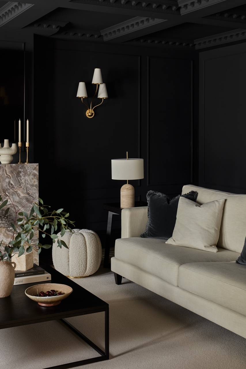 Elegant reception room view highlighting charcoal grey wall panelling, classic brass sconces, and refined interior styling, ideal for high-end apparel campaigns, Love Locations.
