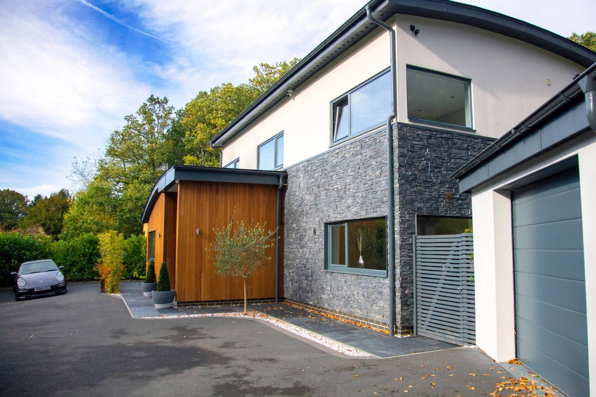 Contemporary luxury house exterior showing a tarmac driveway and mixed-material architectural finishes for car commercial shoots, Love Locations.