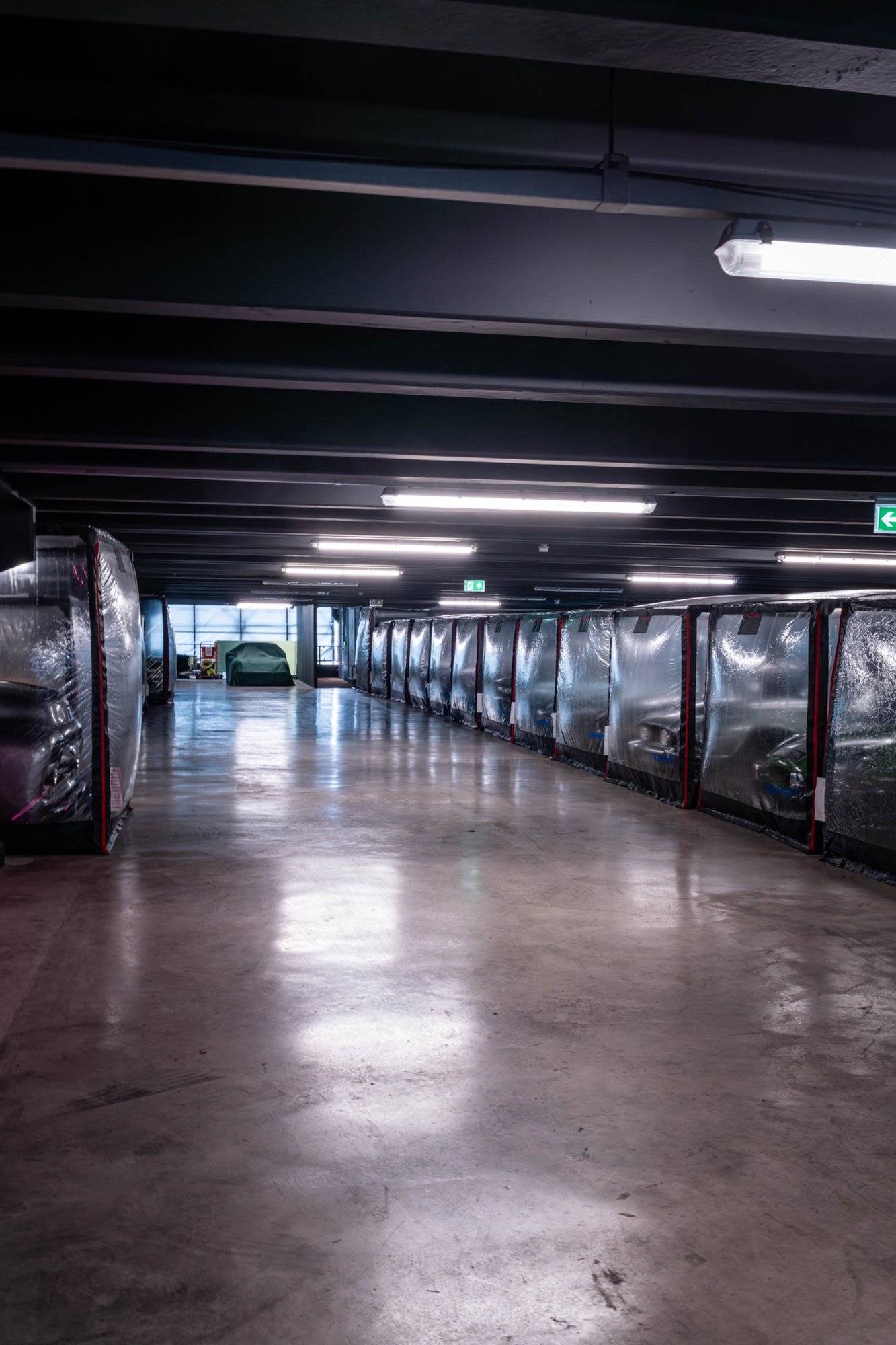 Polished concrete showroom floor reflecting overhead track lights in a West London car storage venue by Love Locations.
