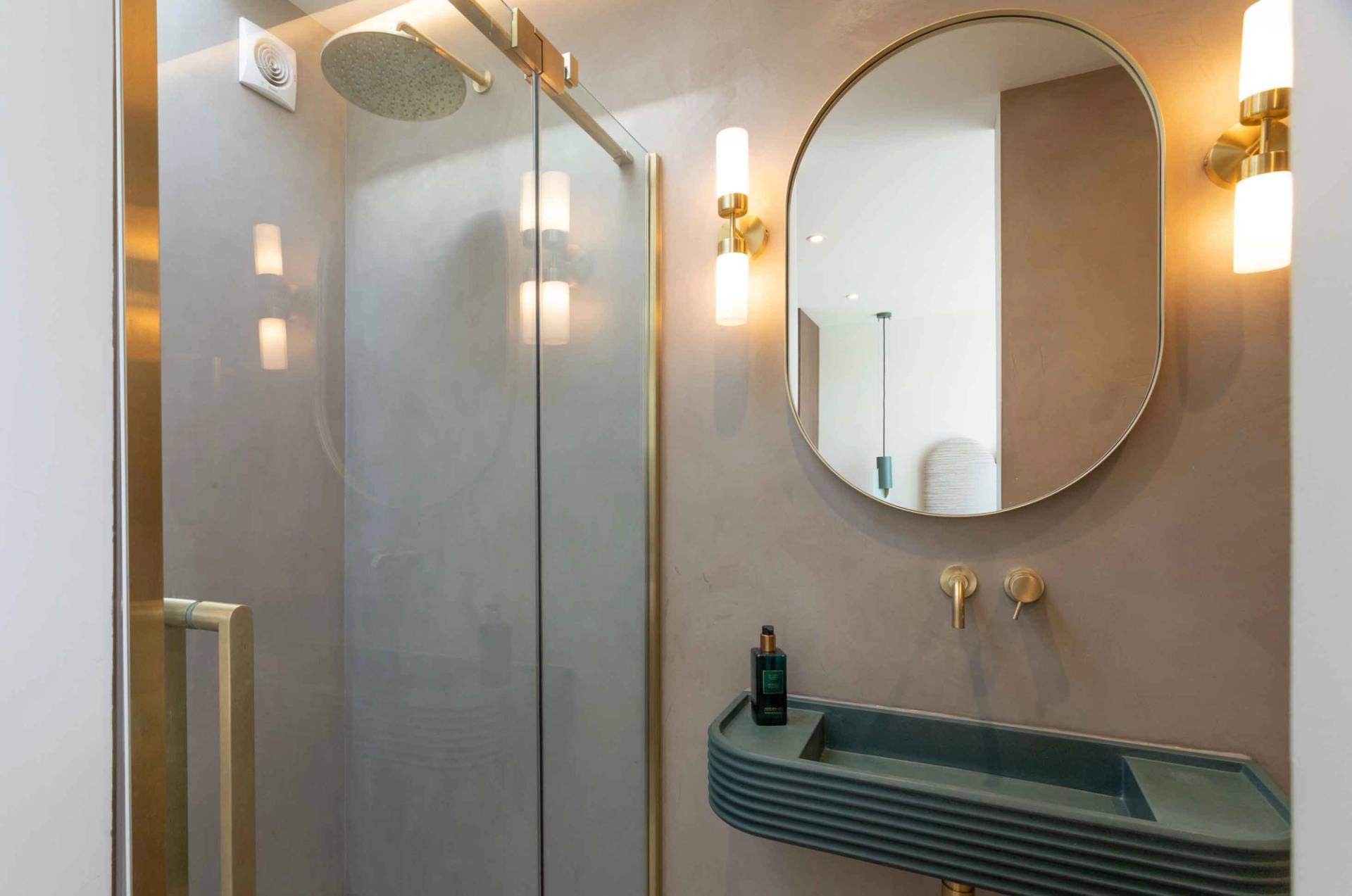Love Locations contemporary bathroom backdrop Godalming: Modern walk-in shower room showing a unique ribbed blue vanity sink basin and brushed gold tapware, ideal for beauty commercials.