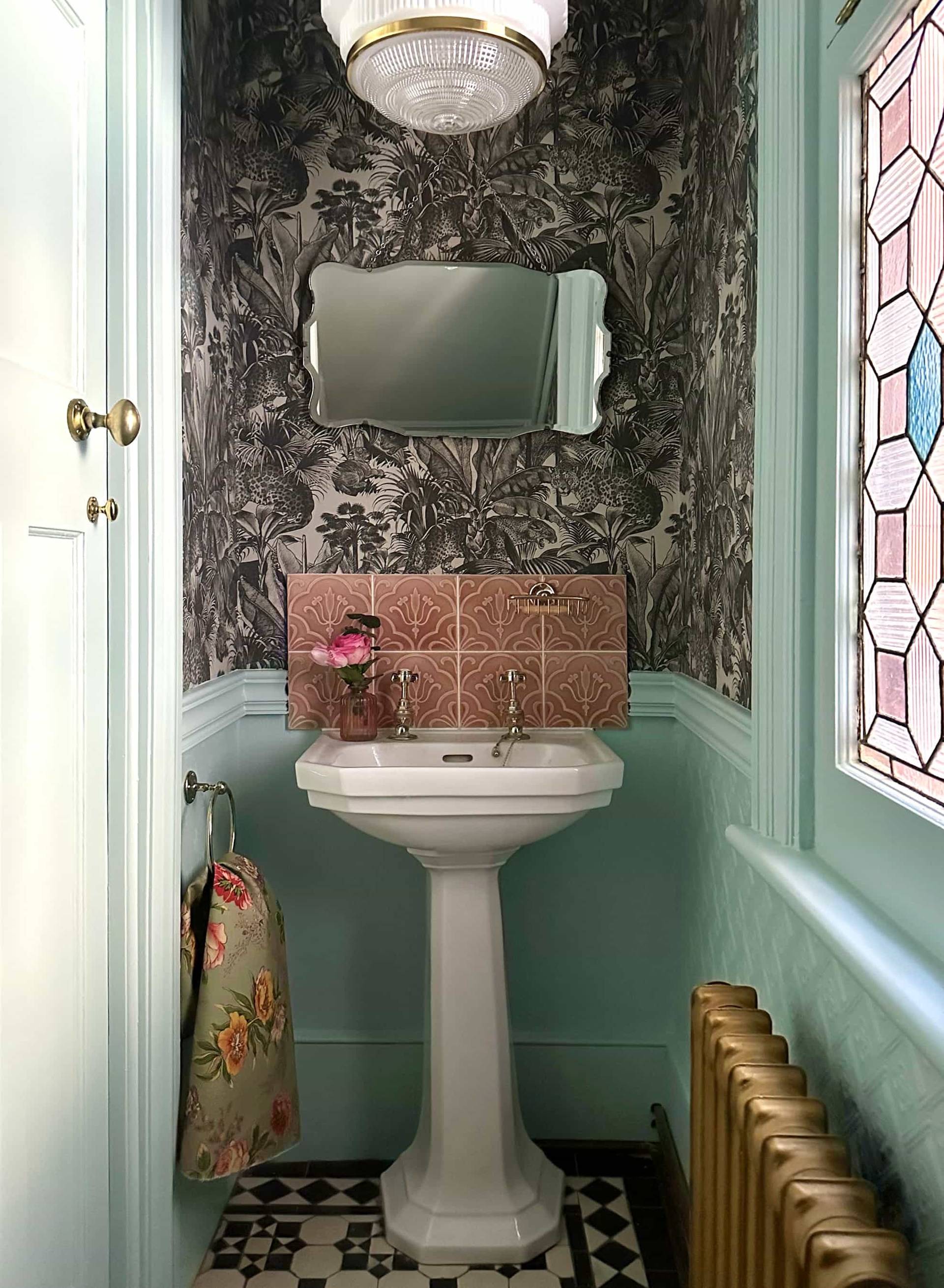 Compact cloakroom bathroom with pedestal sink, pink tiled splashback, and wallpapered walls, Love Locations N13.