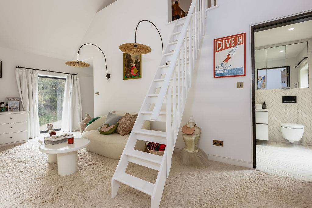 Children's bedroom featuring a white wooden loft ladder leading to a cozy sleeping platform, Love Locations GU32.
