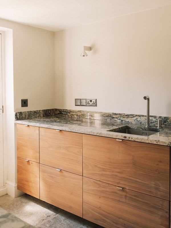 Modern wooden kitchen cabinetry paired with patterned granite countertops and a sleek sink unit, ideal for cooking show productions, Love Locations SW9.