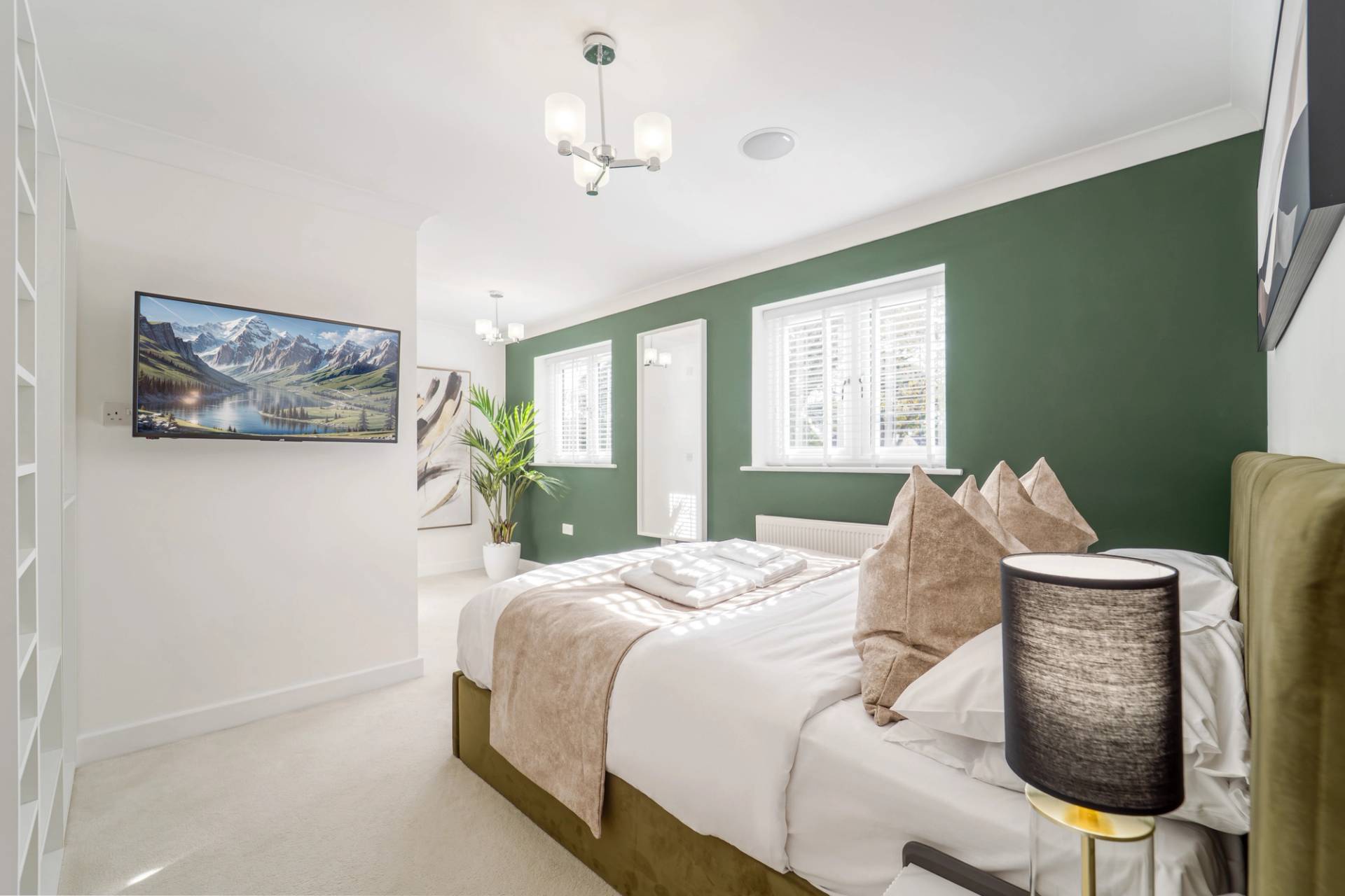 Modern bedroom with olive green feature wall, double bed frame, and neutral accessories, Love Locations RM11.