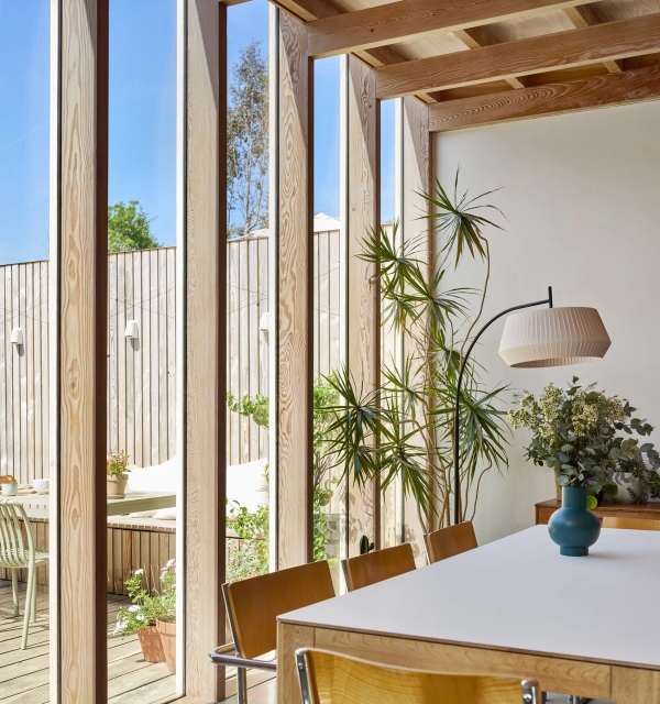 Full-height floor-to-ceiling glass windows framing a bright dining room nook with indoor plants, Love Locations E17.