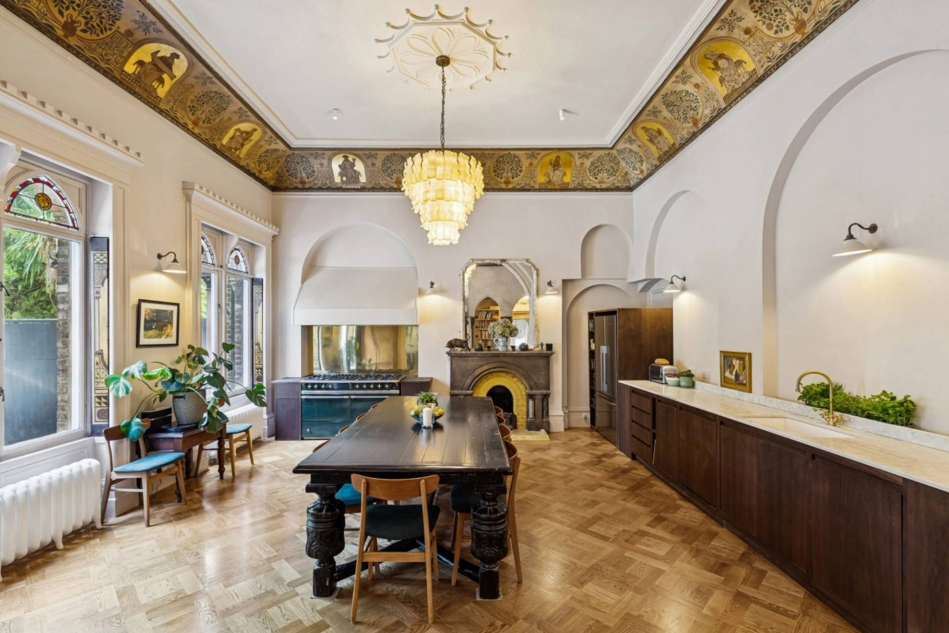 Grand dining room film location in a gothic style home in Hampstead NW3 from Love Locations, featuring a long dark wood table, chandelier, and gilded ornate ceiling fresco.