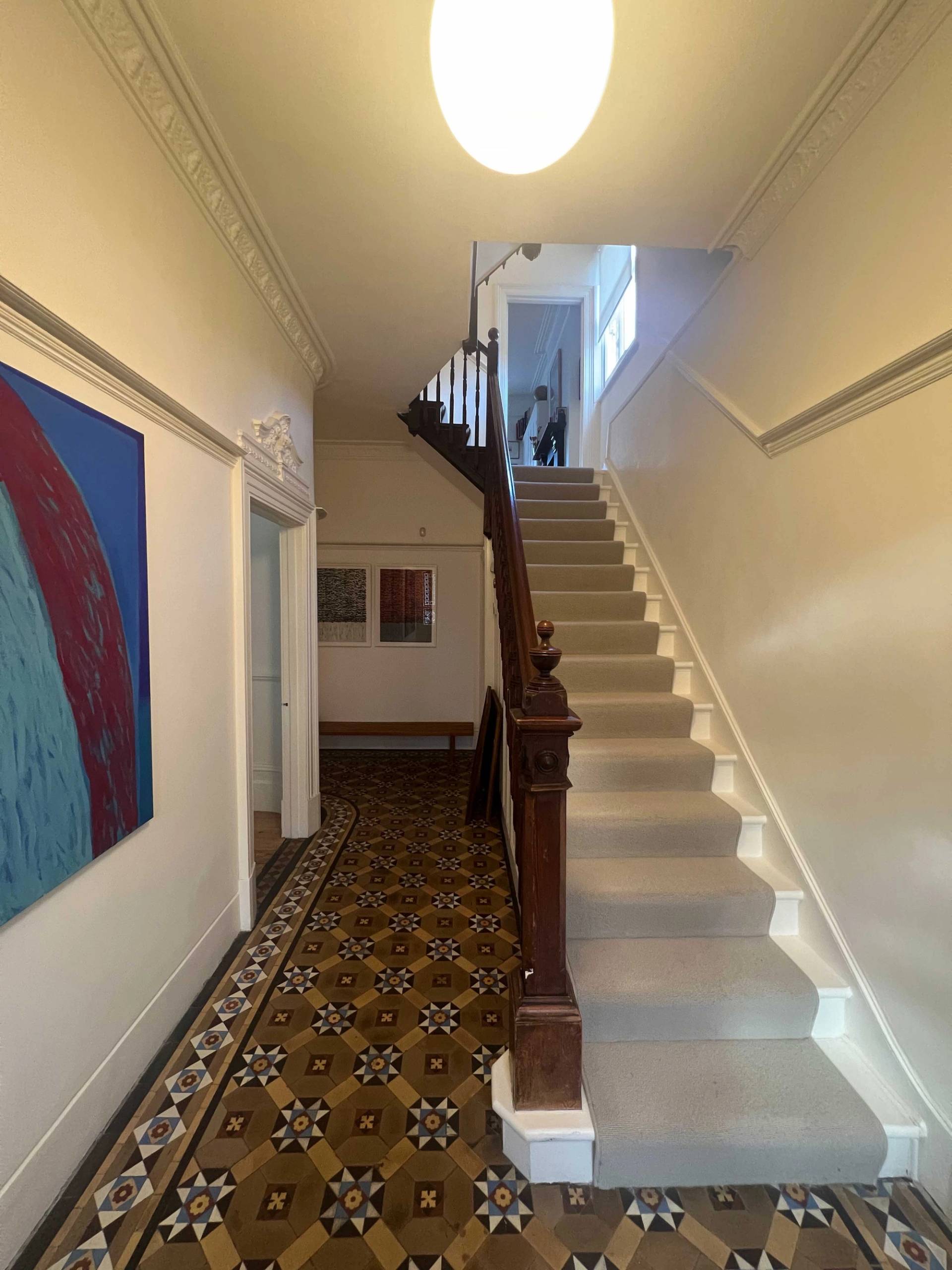 Victorian staircase with dark wood banisters, white spindles, and patterned mosaic hallway flooring, Love Locations SE5.