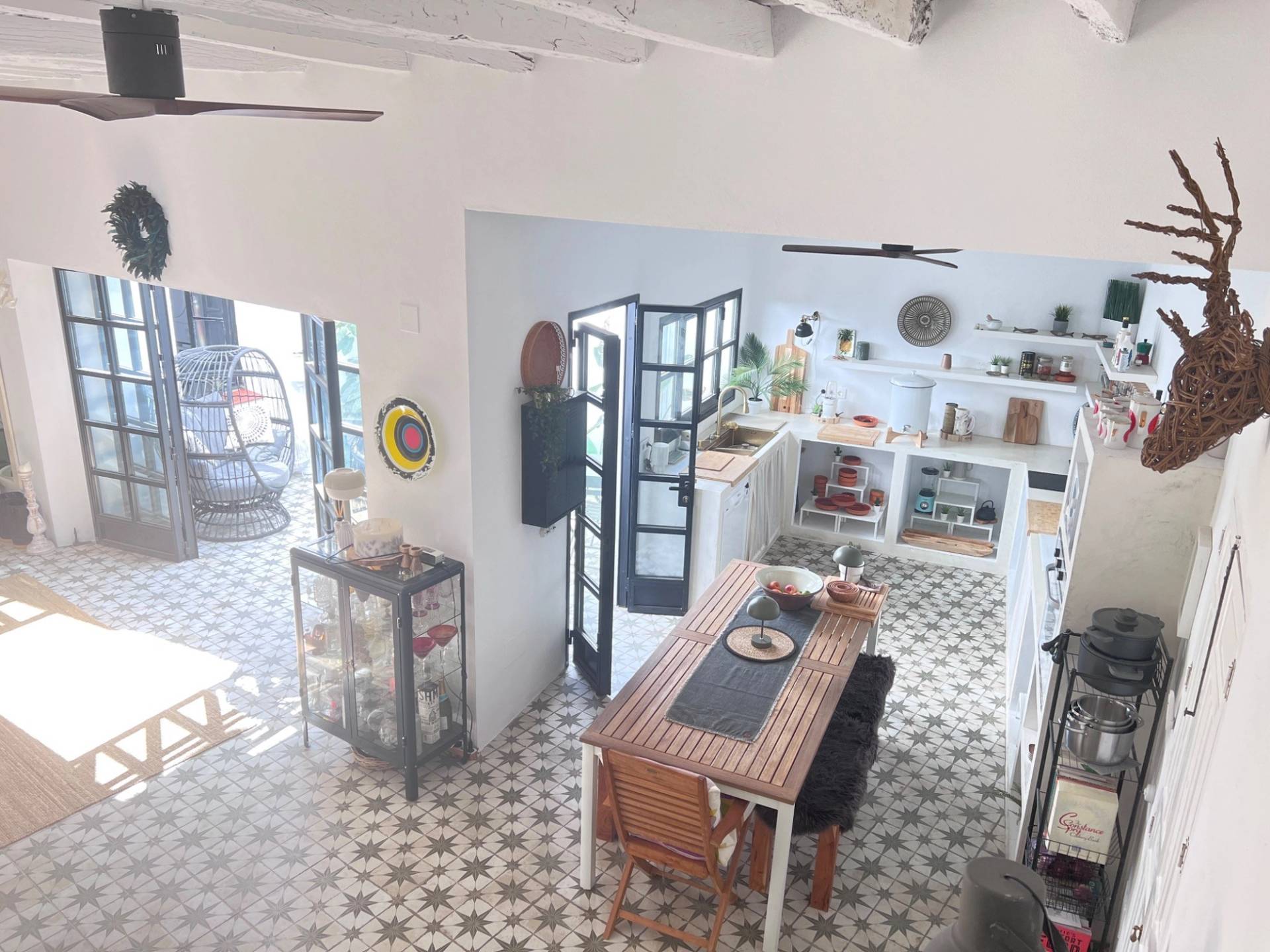 Bright open-plan kitchen and dining area in a Spanish location home in Jimena de la Frontera through Love Locations, with patterned tiles and rustic wooden furniture.