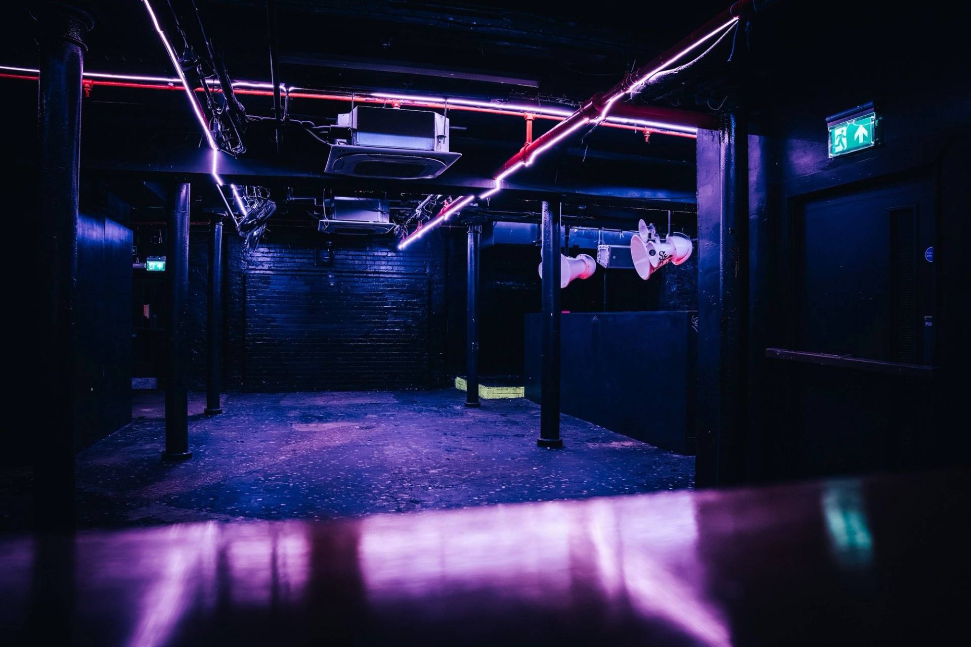 Wide view across a dark purple-lit performance hall in a Cheetham Hill venue for commercial filming by Love Locations.