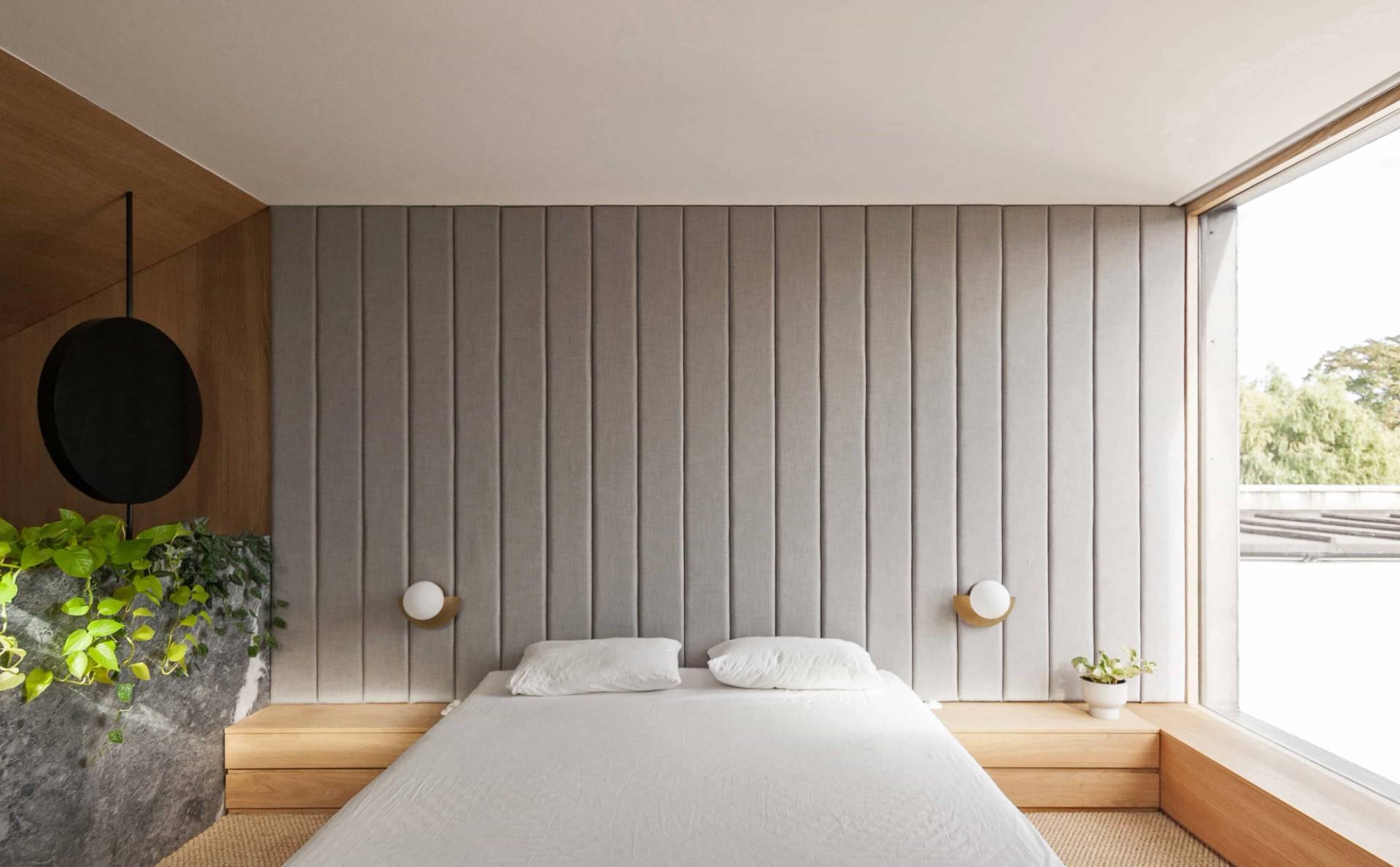 Minimalist master bedroom shoot location in Hackney London N16 from Love Locations, featuring vertical timber-panelled headboard walling and soft wall sconce lighting.