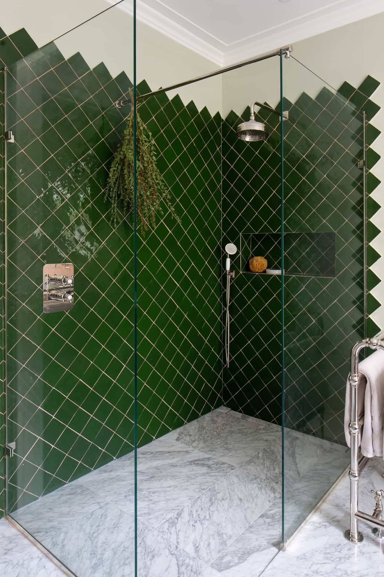 Close-up detail of green diamond wall tiles and brass shower fixtures in Camberwell, SE5 via Love Locations.
