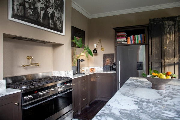 Dark wood kitchen prep area featuring veined grey marble counters and integrated appliances, Love Locations ME13.