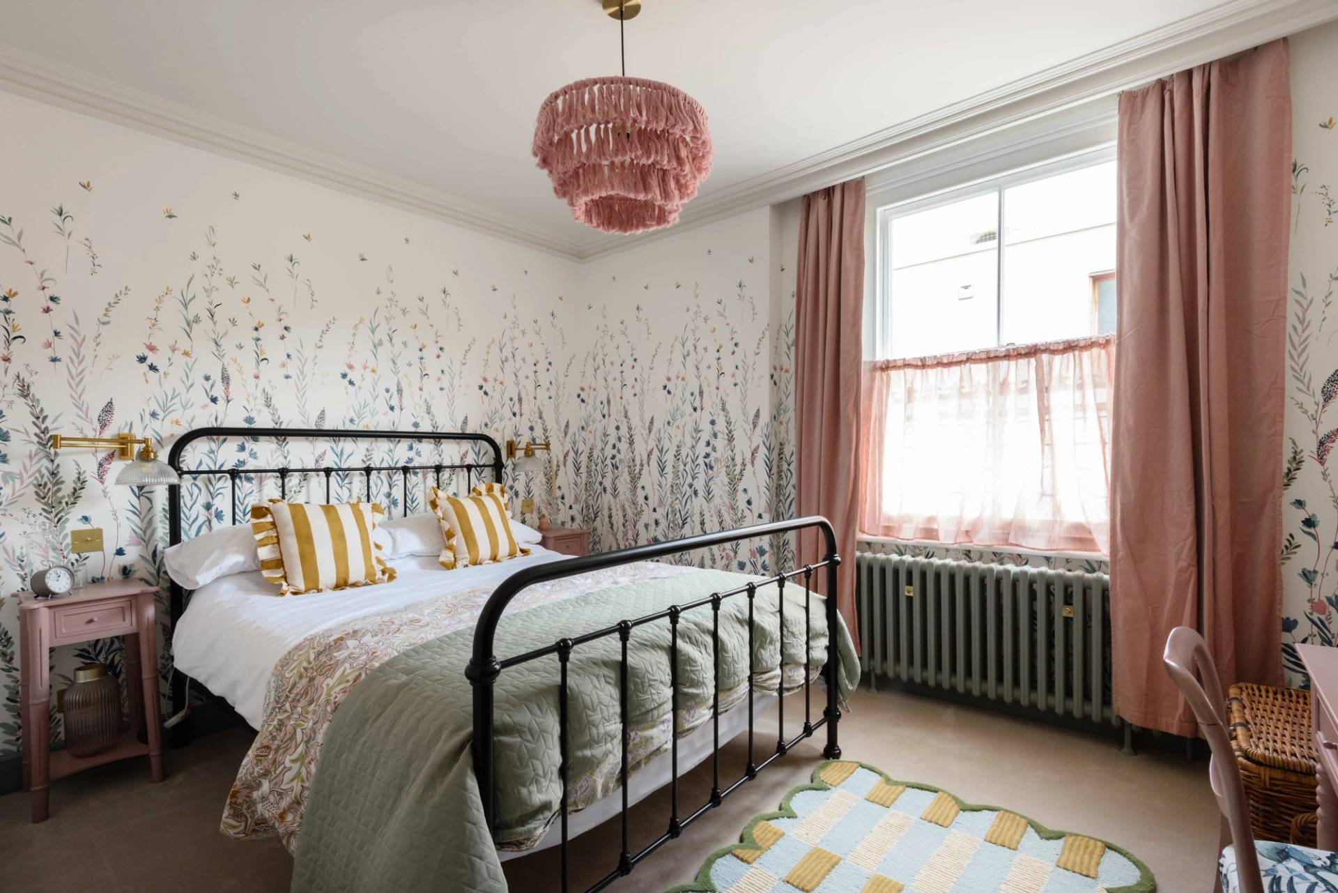 Kids bedroom suite featuring an iron bed frame, pink fringed lampshade, and botanical wall mural, Love Locations TW11.