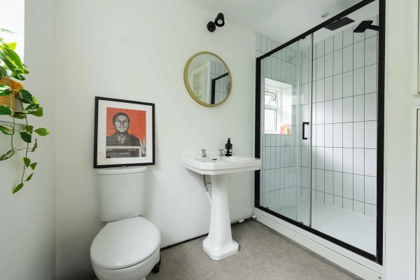 Love Locations monochrome style bathroom Forest Gate: Clean, light-filled bathroom with a statement grid shower screen and minimalist fixtures, perfect for product placement and commercial filming.