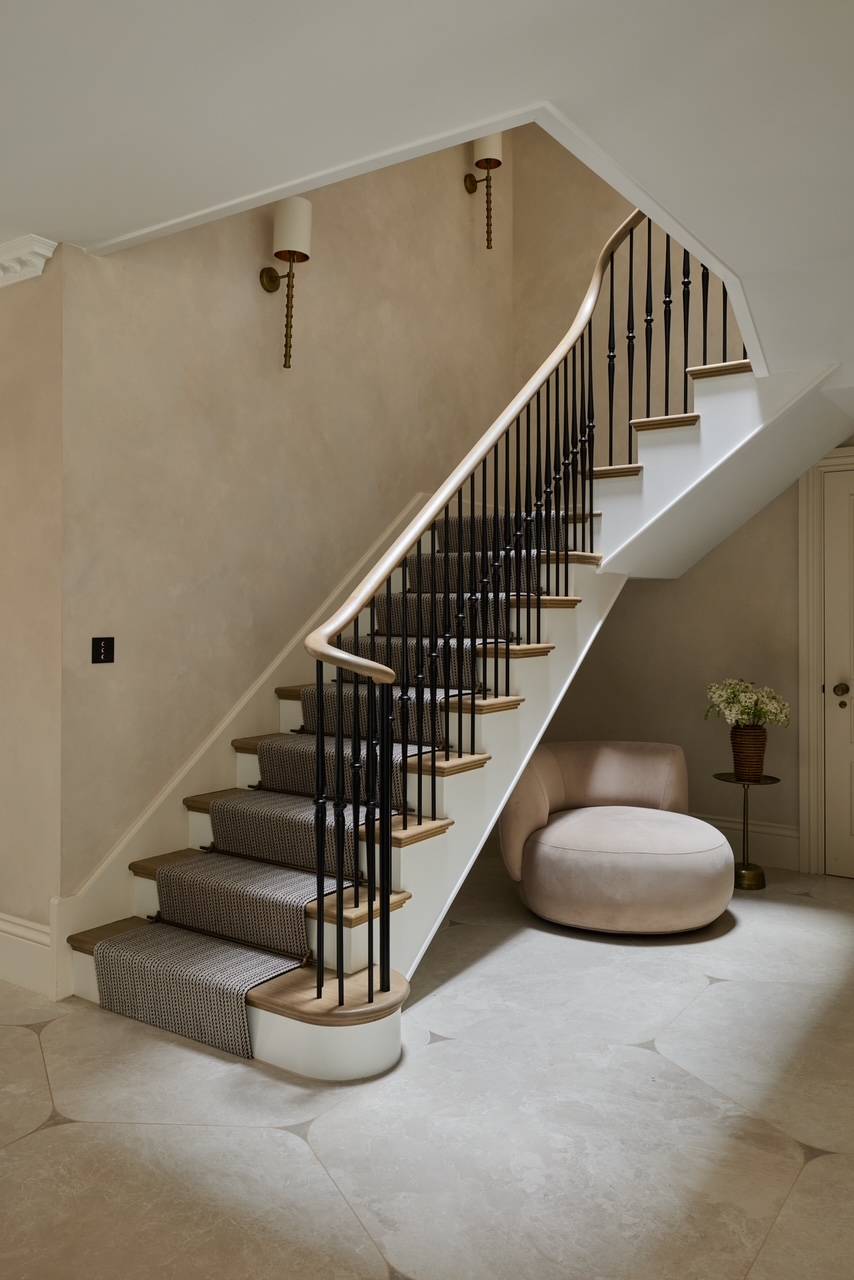 Bright hallway landing showing a beautifully curved wooden banister and a plush velvet ottoman seat, ideal for premium carpet and flooring promotions, Love Locations.