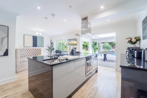 Modern open-plan kitchen prep island facing floor-to-ceiling glass patio doors, Love Locations RM11.