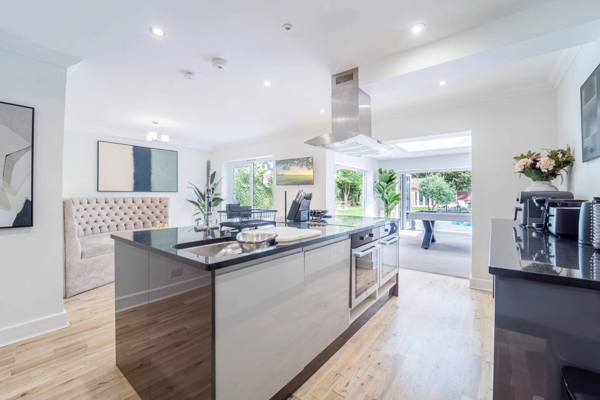 Modern open-plan kitchen prep island facing floor-to-ceiling glass patio doors, Love Locations RM11.