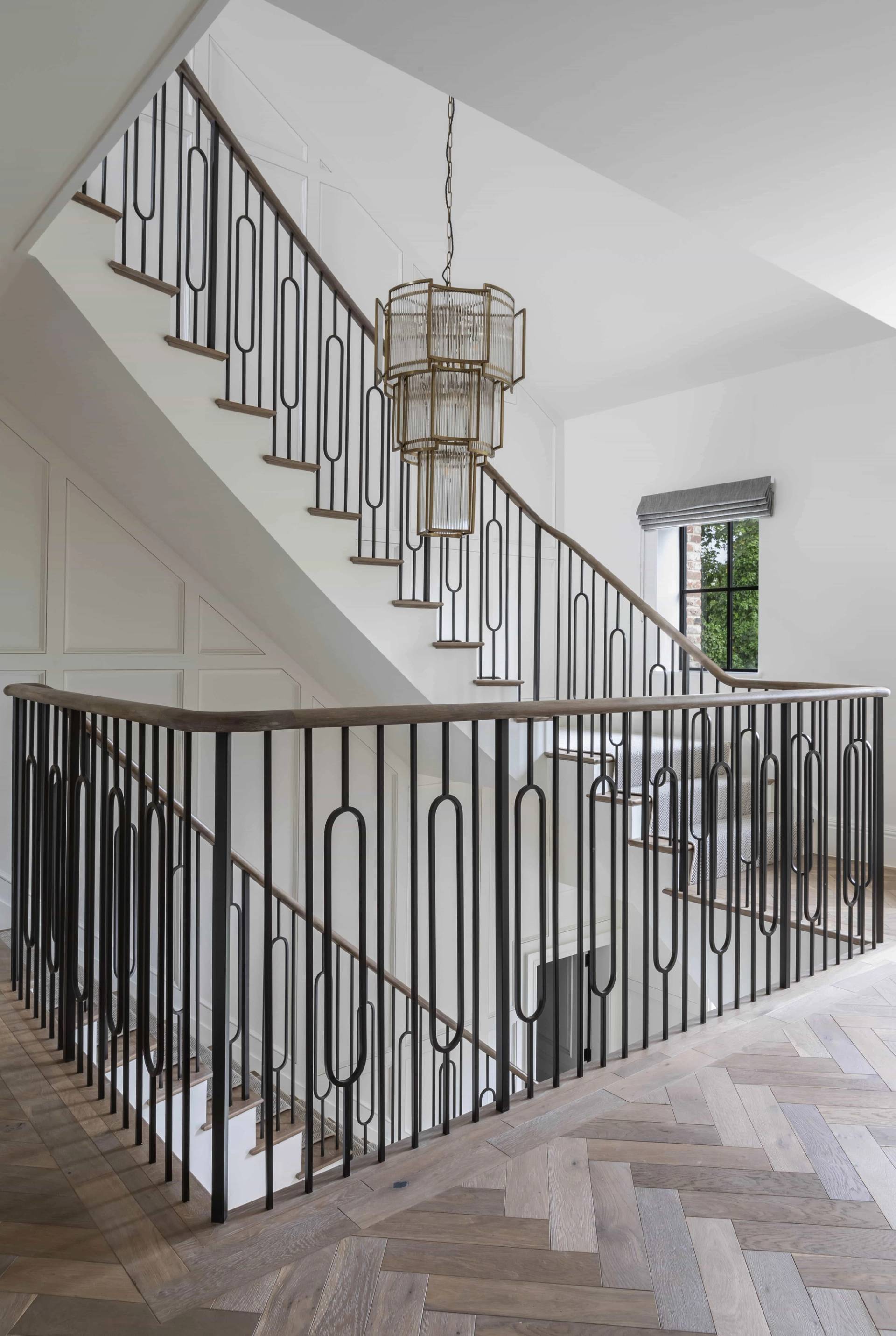 Galleried landing with black iron stair railings and a multi-tiered crystal chandelier, Love Locations HP18.