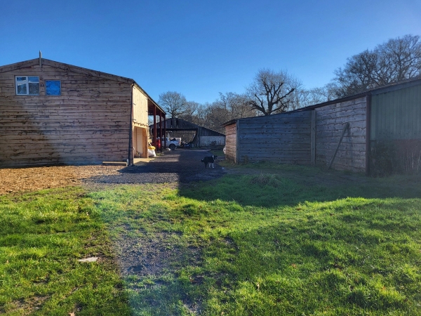 Rustic farm yard surrounded by timber outbuildings and green lawns in South Chailey, Love Locations BN8.