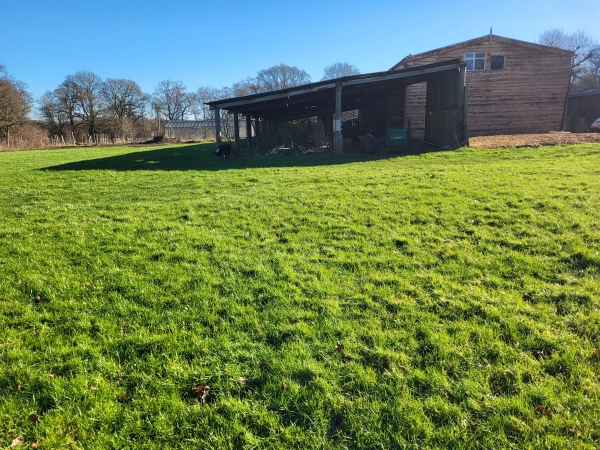 Rustic wooden open-fronted barn outbuilding on a grassy field shoot location in South Chailey, Love Locations BN8.