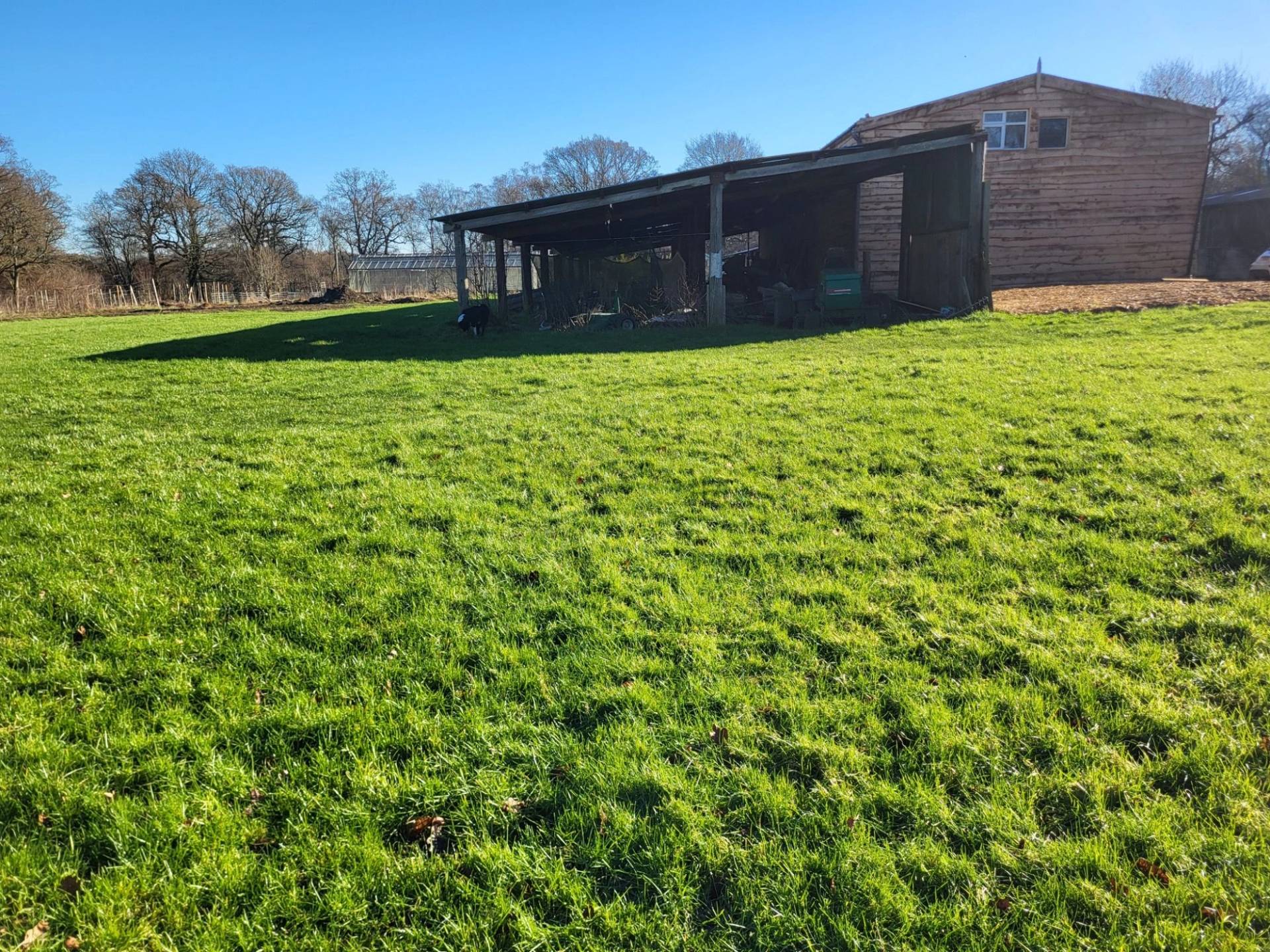 Rustic wooden open-fronted barn outbuilding on a grassy field shoot location in South Chailey, Love Locations BN8.