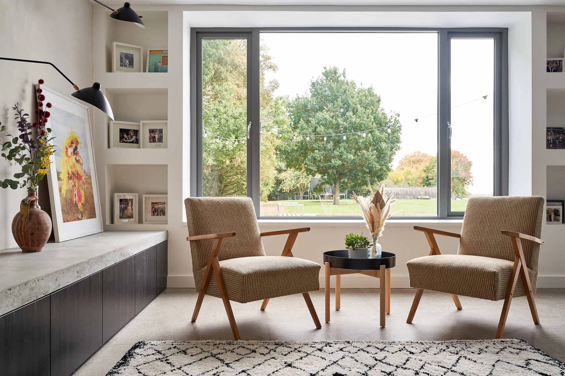 Lounge seating area with vintage armchairs set beside a large picture window framing countryside views, Love Locations IP30.
