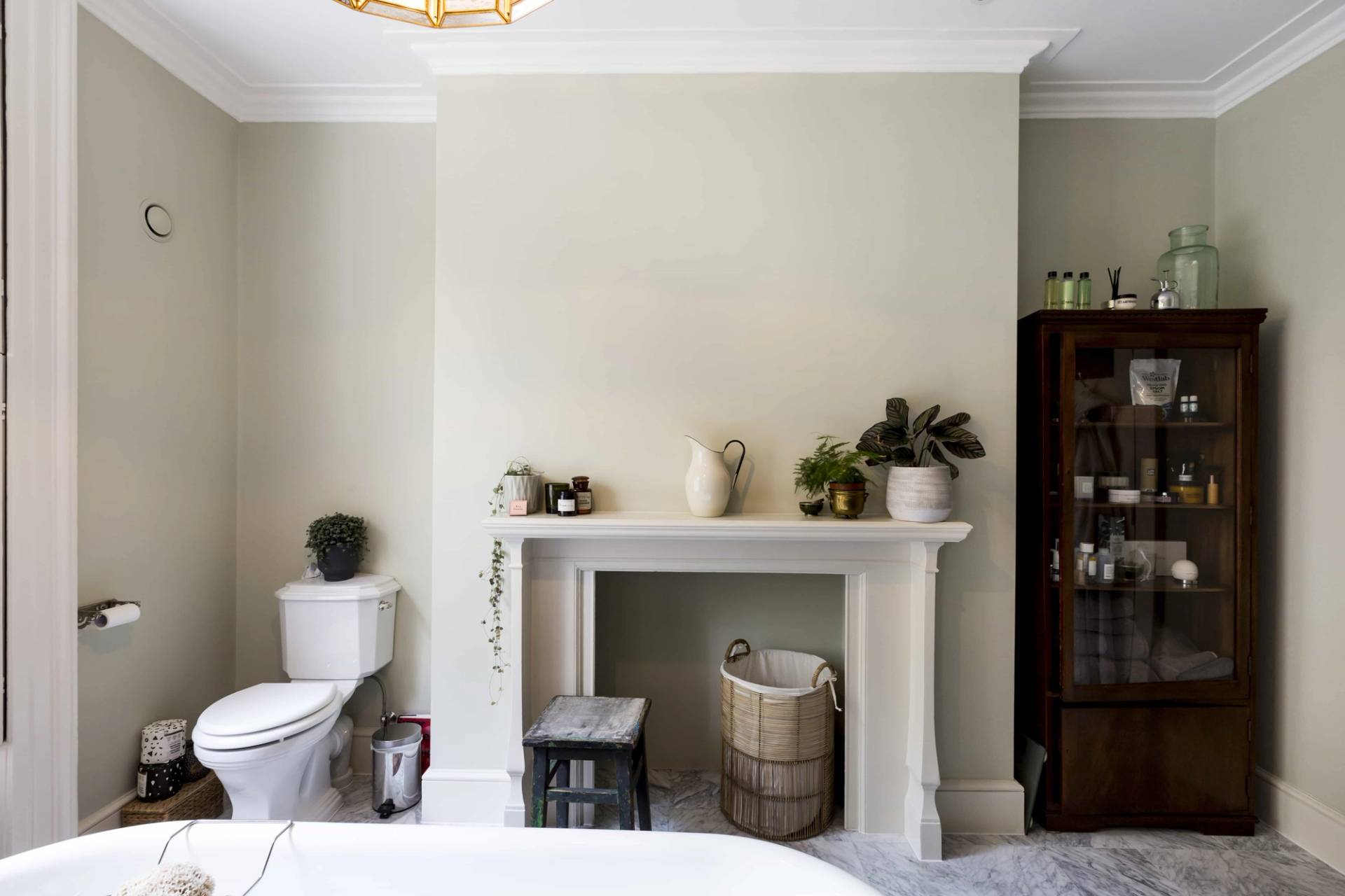 Minimalist bedroom or dressing room with white fireplace surround and neutral decor in Camberwell, SE5 via Love Locations.