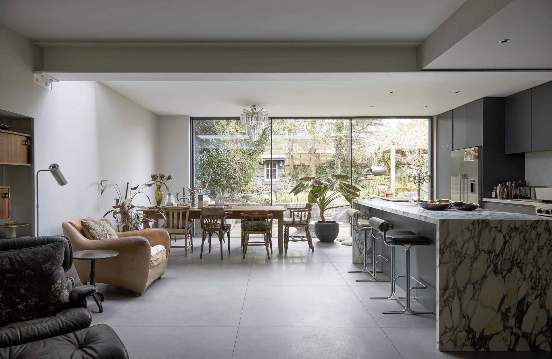Open-plan kitchen extension with full-height glass sliding doors, dining table, and marble kitchen island, Love Locations Finsbury Park.