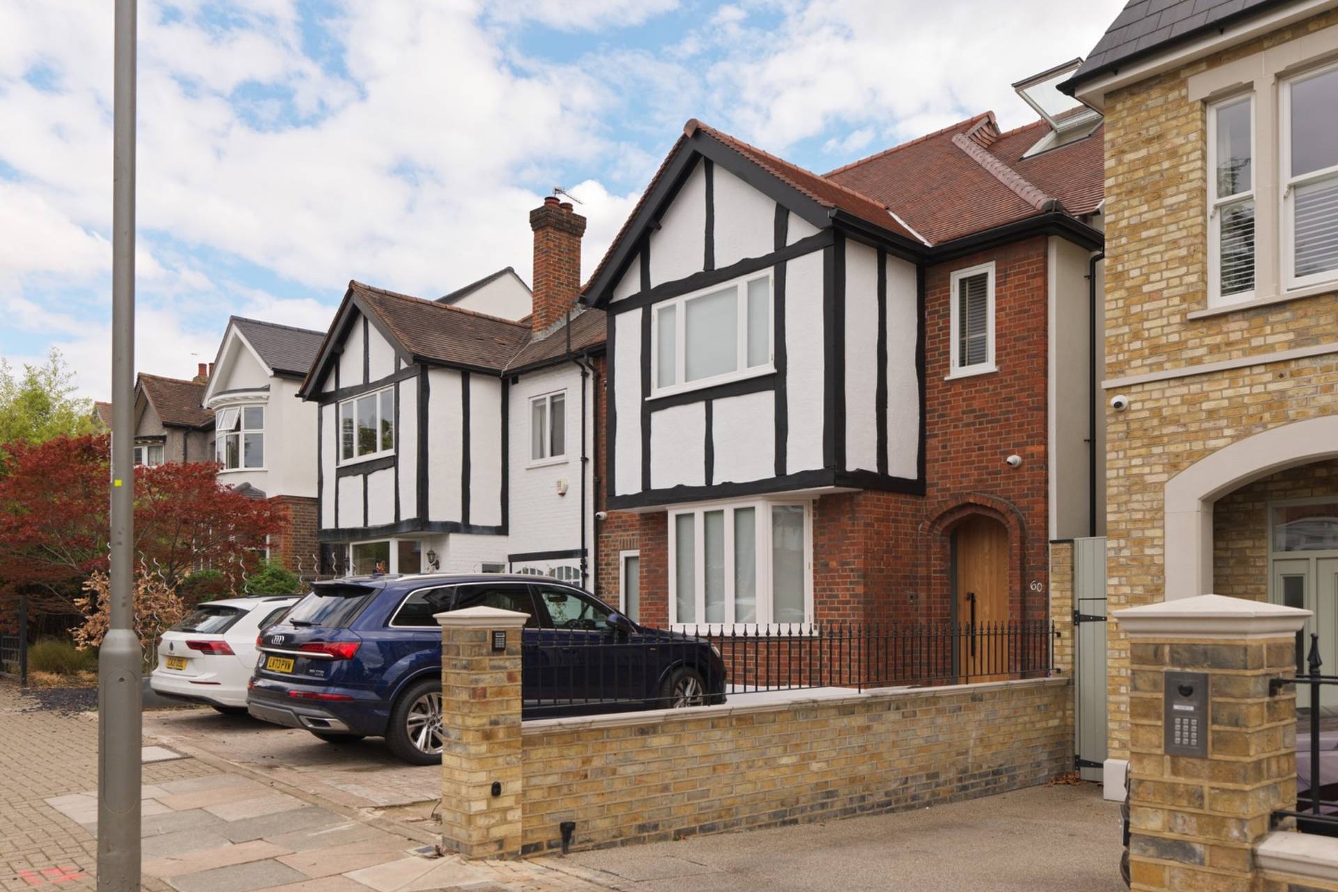Exterior front view of a mock-Tudor and red-brick modern family house in Clapham South SW11 through Love Locations.