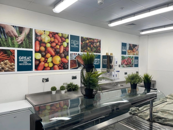 Love Locations commercial kitchen location Reading: Modern stainless steel school servery and lunch counter with food displays, tailored for corporate media and institutional product placement.