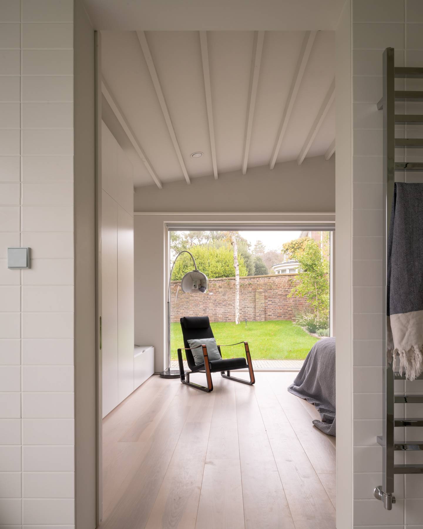 Master bedroom suite with sliding glass patio doors opening directly onto a private garden lawn, Love Locations BN3.