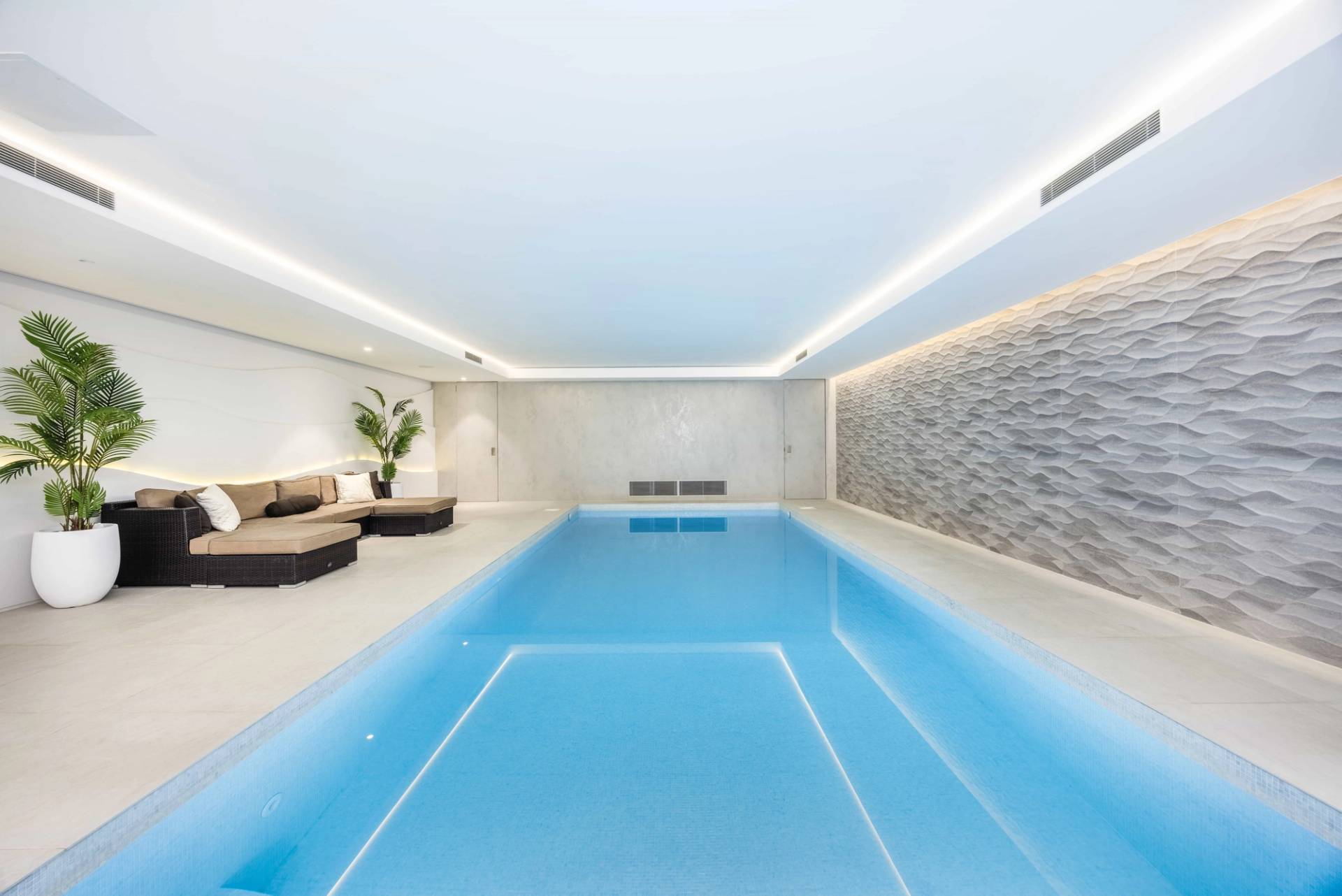 Heated indoor pool hall set under mood lighting with luxury sofa seating, Love Locations WD7.