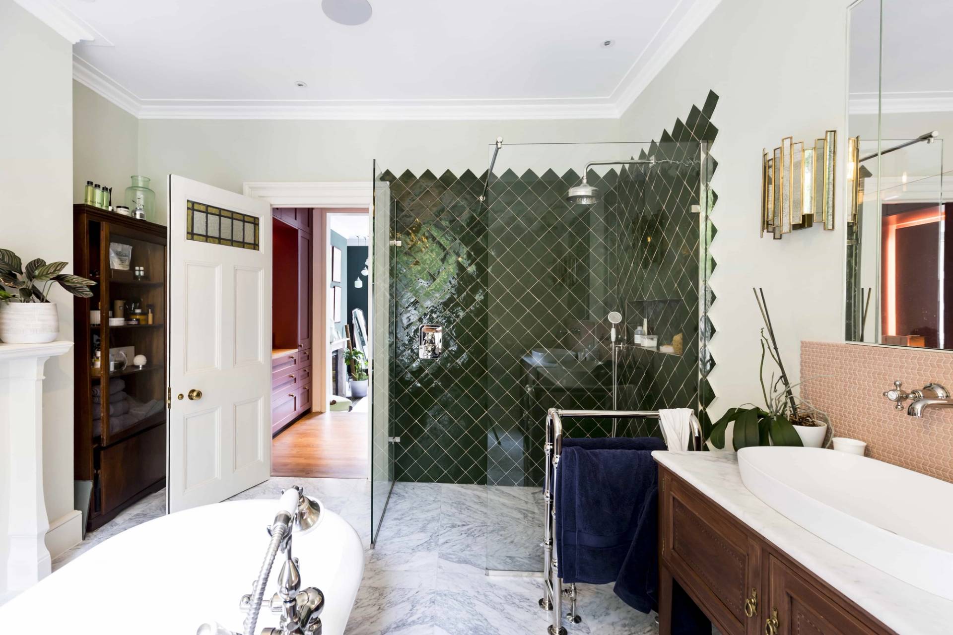 Modern walk-in shower room with green geometric diamond wall tiles and marble floors in SE5 via Love Locations.