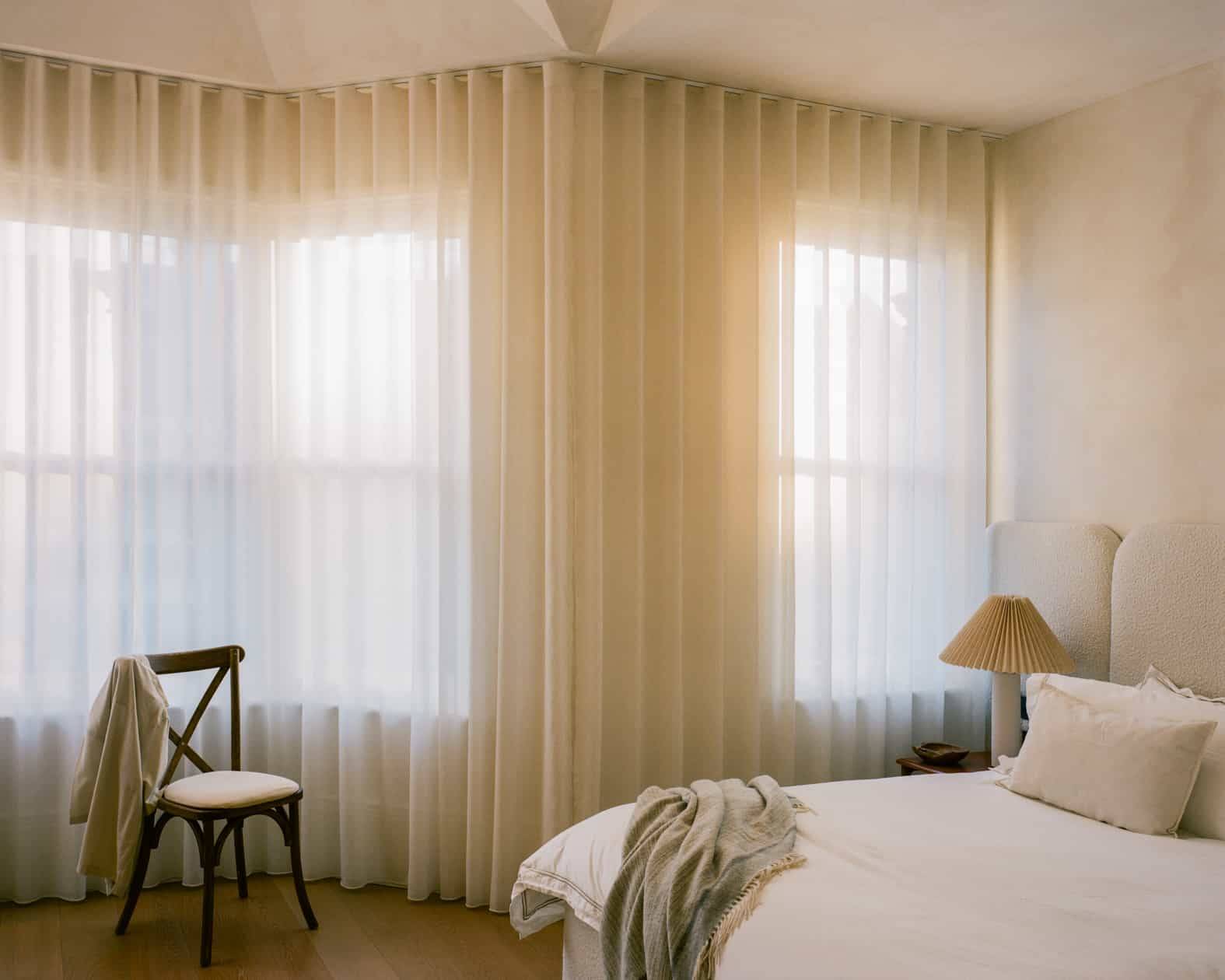Serene bedroom setup with soft sheer window drapes, linen bedding, and neutral plaster finishes, ideal for wellness brand ads, Love Locations SW4.