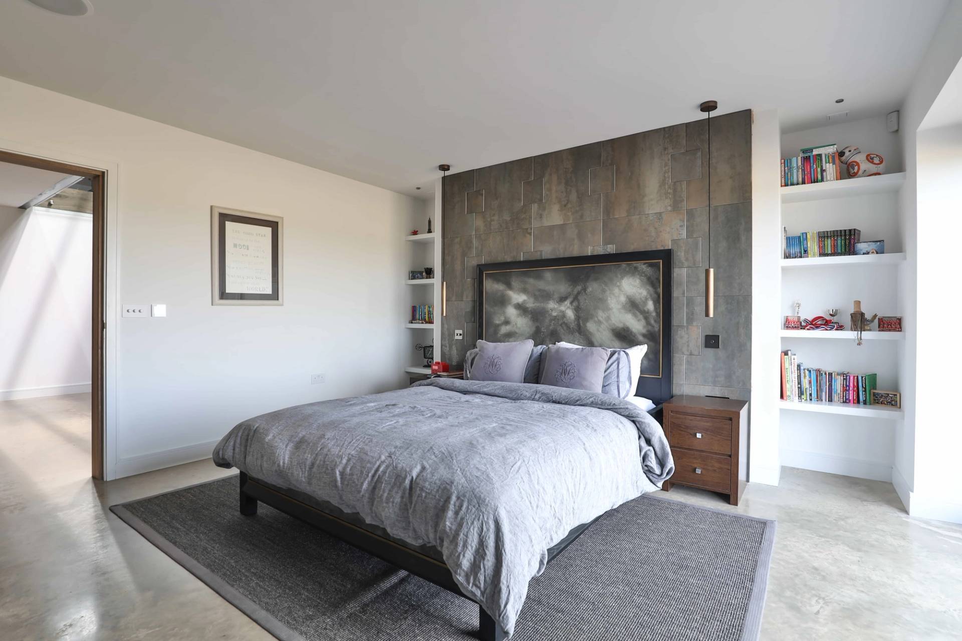 Luxury bedroom suite with grey velvet headboard, stone-effect wall panelling, and neutral carpet, Love Locations CV23.
