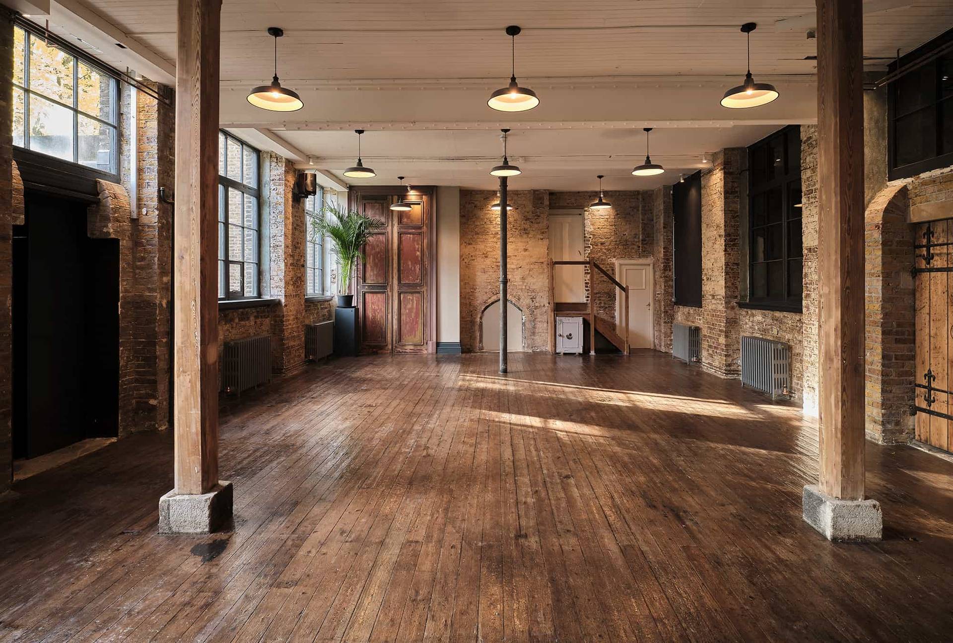 Atmospheric industrial warehouse space featuring brick walls, wooden pillars, and natural light, Love Locations E2.