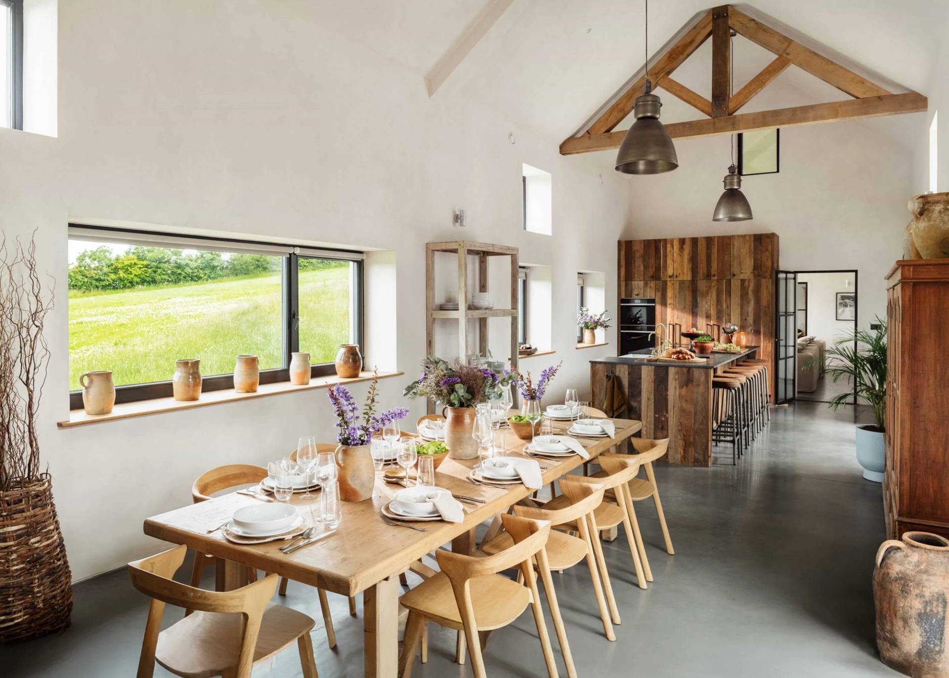 Wide view of a rustic dining and event room in Castleblayney County Monaghan Ireland through Love Locations, featuring vaulted ceilings with exposed wood trusses and large windows.