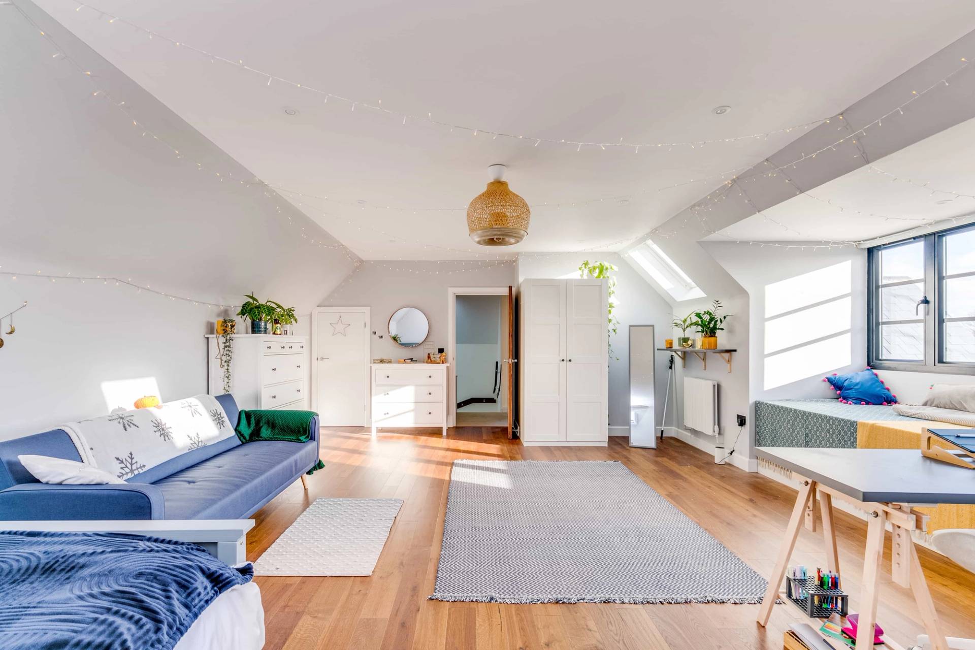 Attic bedroom suite with wood floors, sloped ceilings, and neutral storage wardrobes, Love Locations CB2.