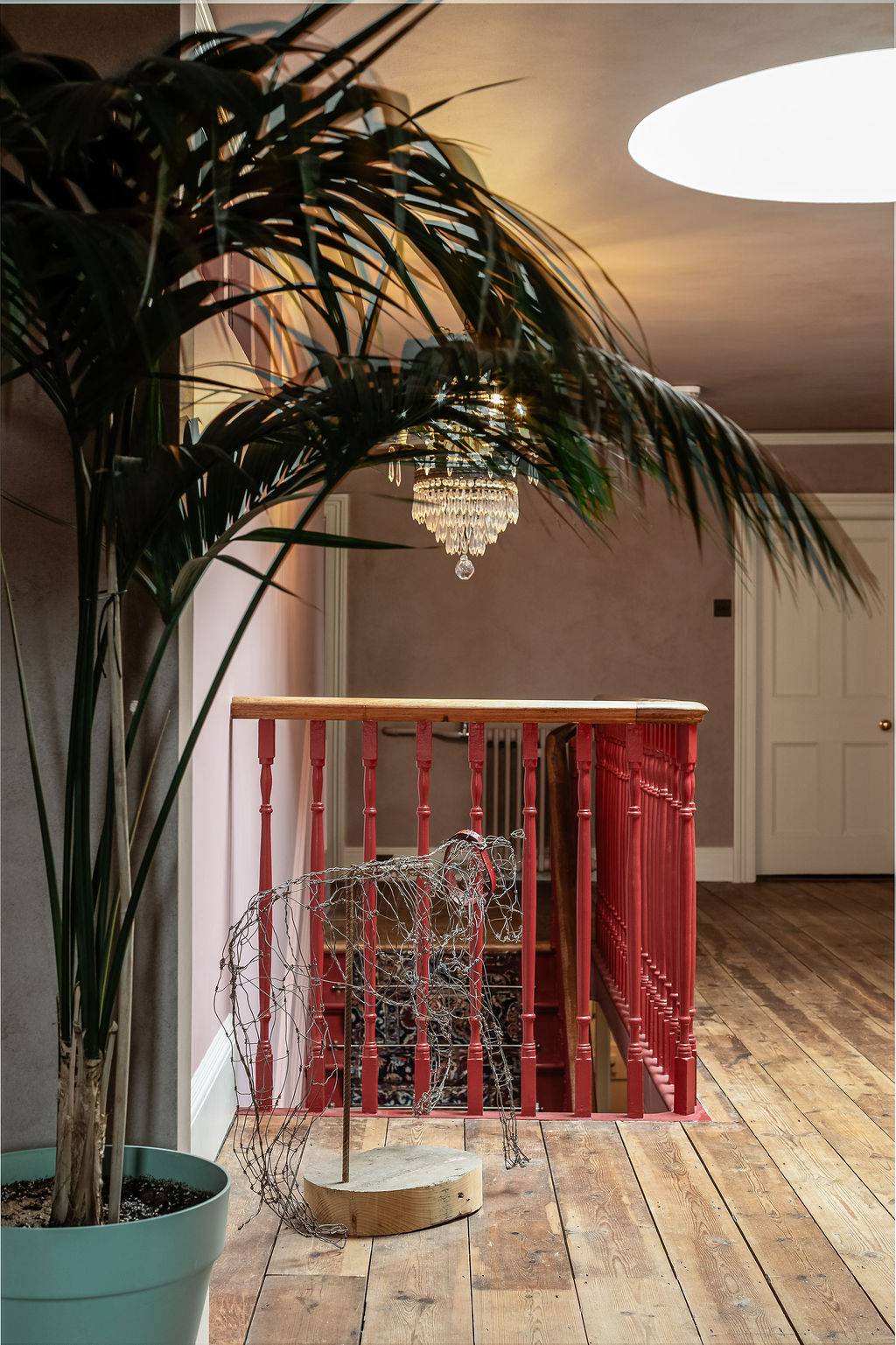 ntimate landing corner featuring a sparkling crystal chandelier and potted indoor palms, an elegant lifestyle backdrop from Love Locations.