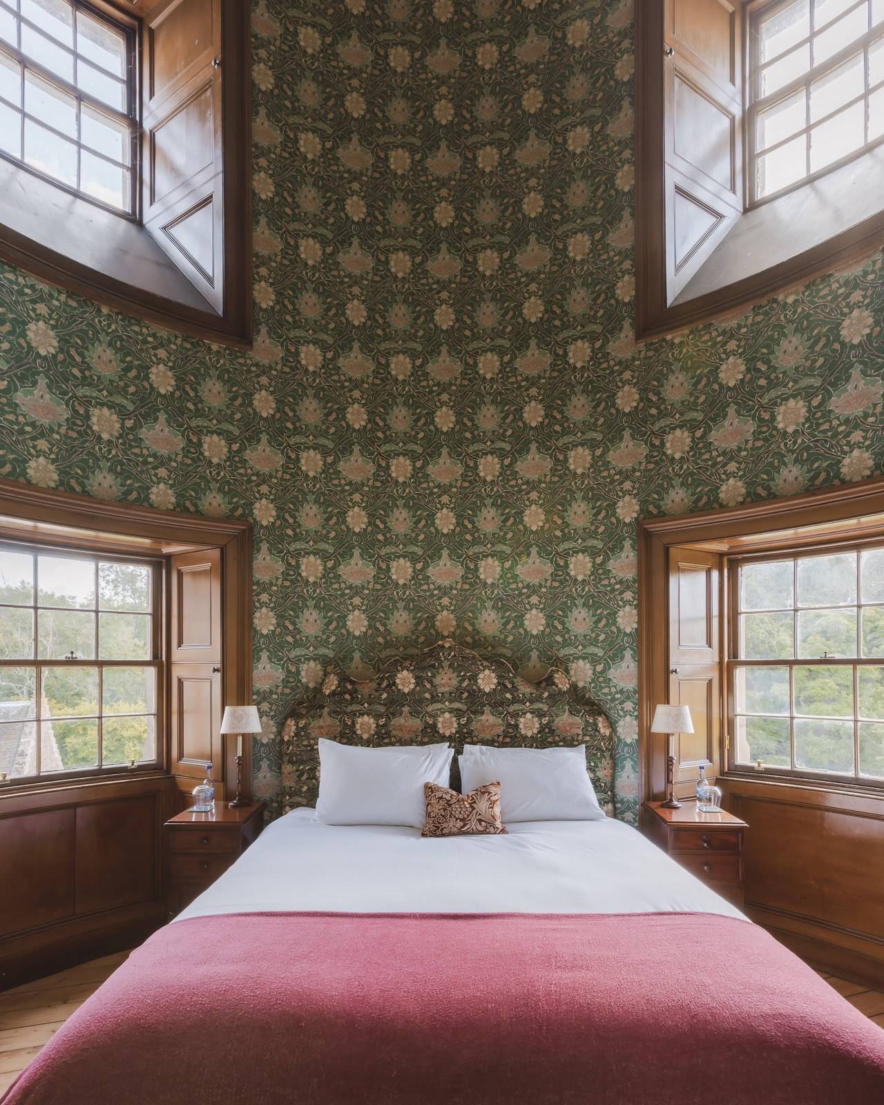 Tower bedroom suite set in a round turret room with green patterned wallpaper and sash windows, Love Locations KY15.