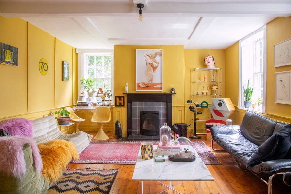 Vibrant yellow panelled reception room with black fireplace, white coffee table, and patterned rugs, Love Locations ME13.