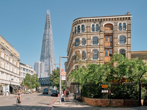 Street-level perspective of The Lounge SE1 with the Shard visible in the background beyond the historic brick buildings.