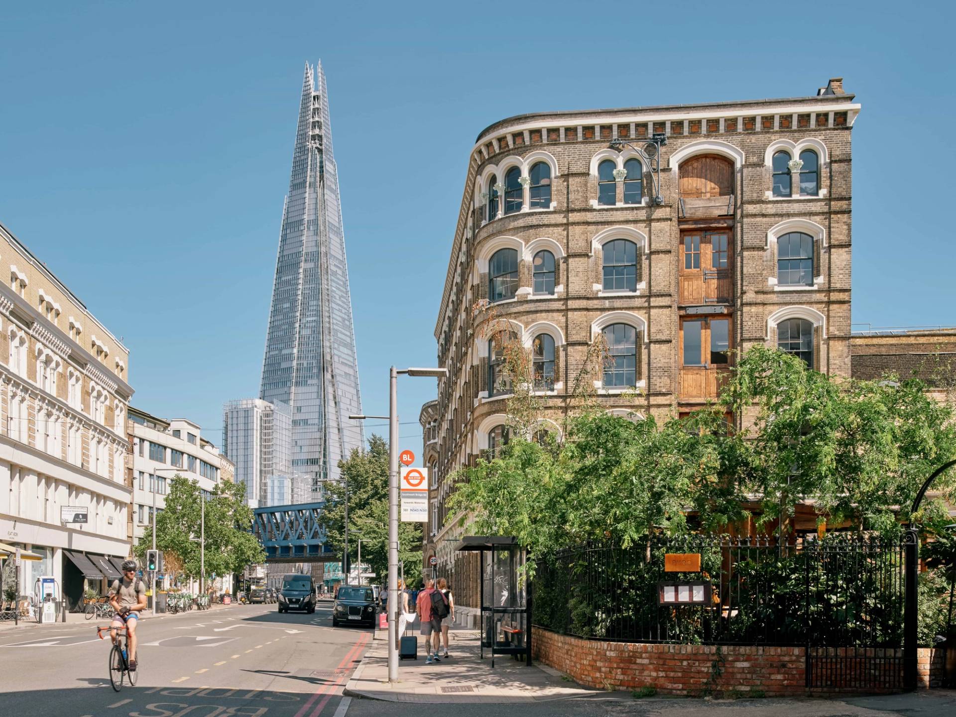 Street-level perspective of The Lounge SE1 with the Shard visible in the background beyond the historic brick buildings.