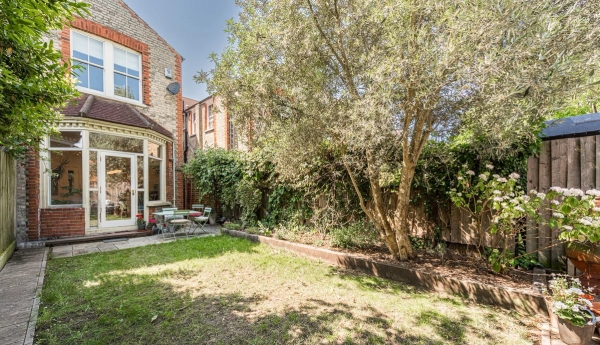 Rear exterior facade view of an Edwardian brick terraced location house with a beautifully landscaped garden, Love Locations.