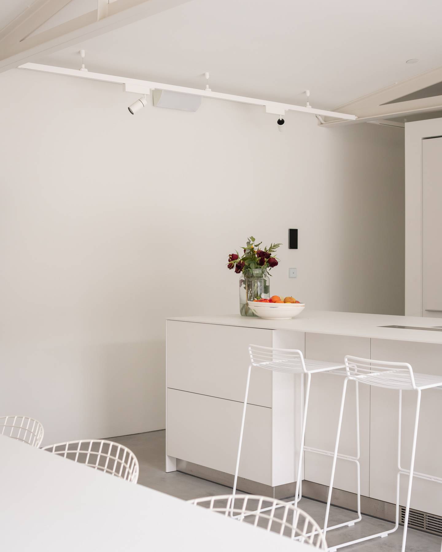 Sleek white kitchen island prep counter set against neutral walls in an architectural home, Love Locations BN3.