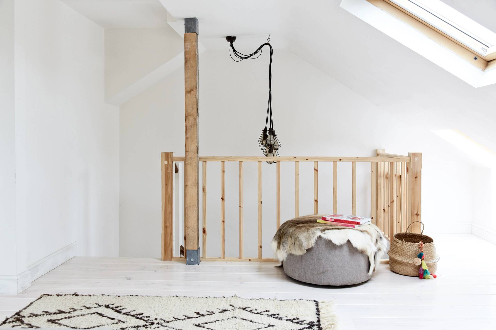 Minimalist loft landing featuring raw plywood wall cladding, wooden balustrade, and pouf seating, Love Locations N13.