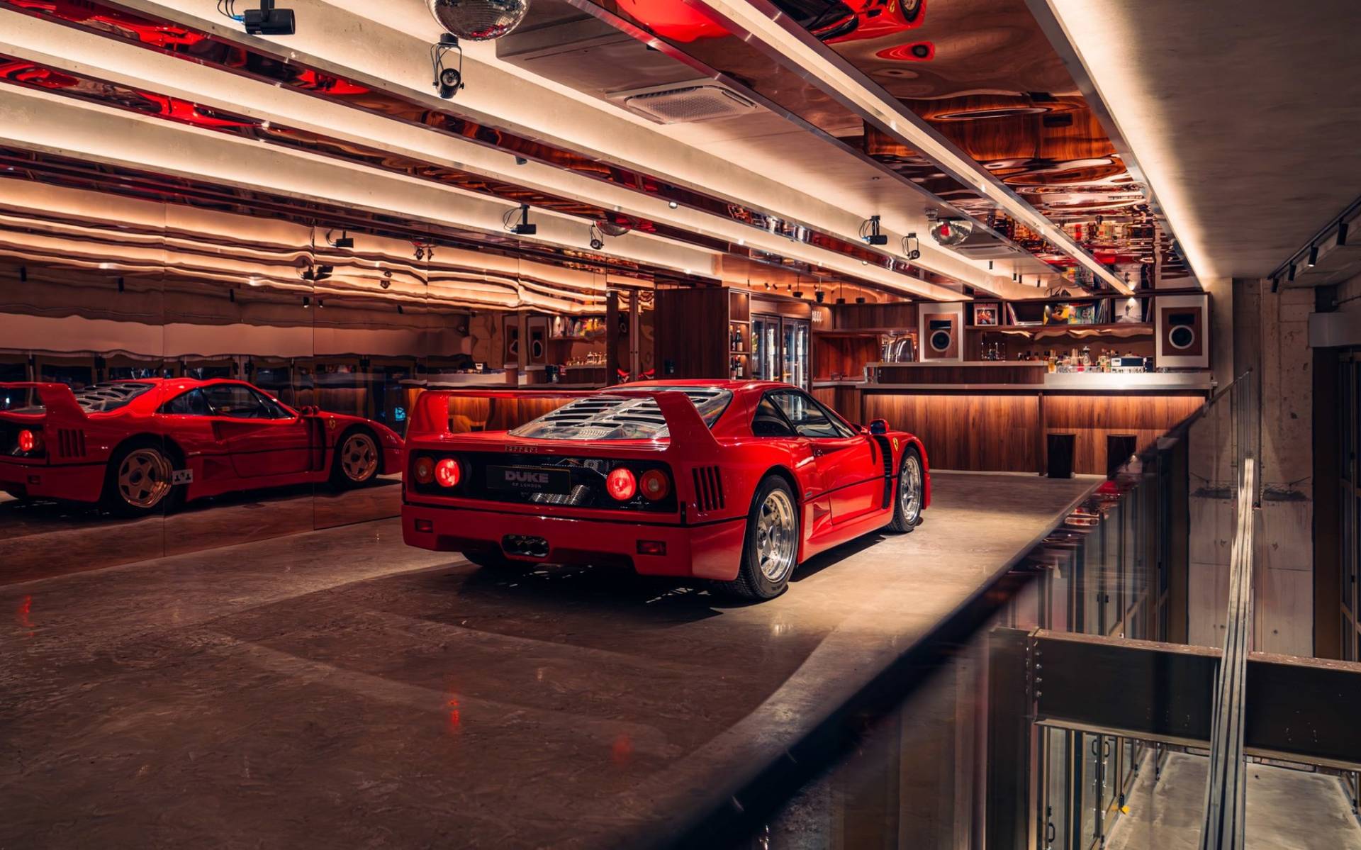 Atmospheric red lighting mood highlighting a classic Ferrari F40 inside Plonkers Listening Bar through Love Locations.